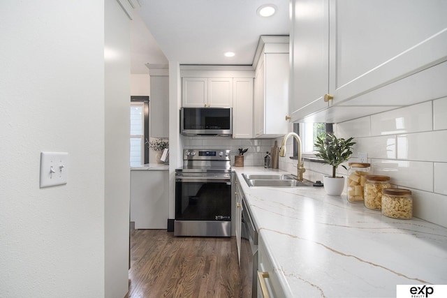 3814 Marcy St, Omaha, NE 68105 - kitchen featuring stainless steel appliances, backsplash, light stone countertops, white cabinetry, and dark wood-style floors
