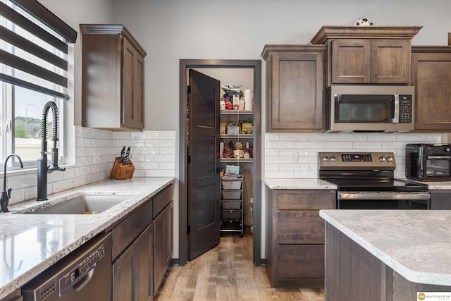 7176 N 166th St, Bennington, NE 68007 - kitchen with appliances with stainless steel finishes, light wood finished floors, backsplash, and light stone countertops