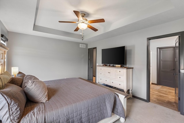 7176 N 166th St, Bennington, NE 68007 - bedroom featuring a tray ceiling, light carpet, and a ceiling fan
