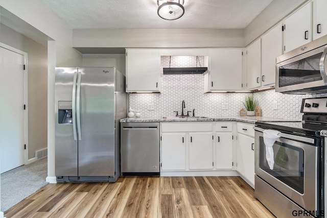 4005 N 213th Cir, Omaha, NE 68022 - kitchen with appliances with stainless steel finishes, white cabinetry, decorative backsplash, light wood-type flooring, and light stone countertops