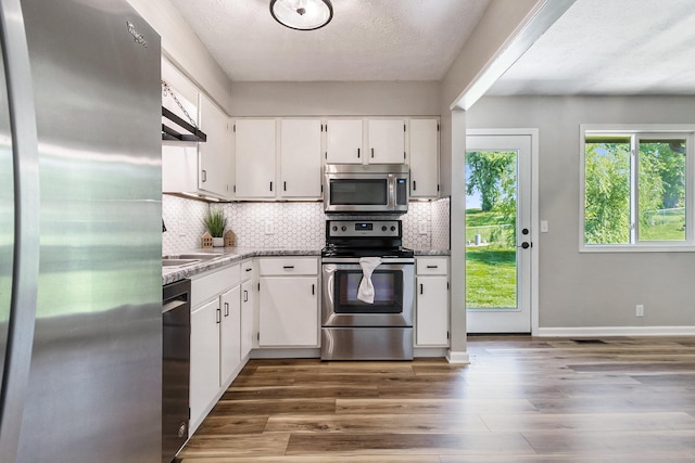 4005 N 213th Cir, Omaha, NE 68022 - kitchen with appliances with stainless steel finishes, white cabinets, dark wood finished floors, decorative backsplash, and a textured ceiling