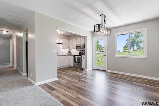 4005 N 213th Cir, Omaha, NE 68022 - kitchen with appliances with stainless steel finishes, white cabinets, a textured ceiling, dark wood finished floors, and pendant lighting