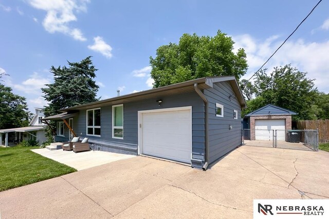 8506 Keystone Dr, Omaha, NE 68134 - ranch-style house featuring an outdoor hangout area, an outdoor structure, and a detached garage