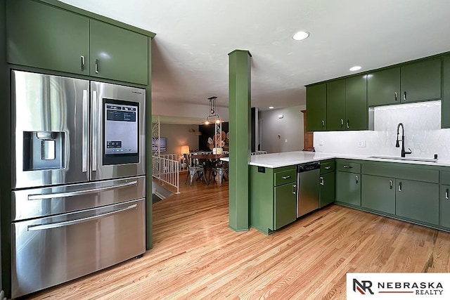 8506 Keystone Dr, Omaha, NE 68134 - kitchen featuring appliances with stainless steel finishes, green cabinets, light countertops, light wood-style floors, and recessed lighting