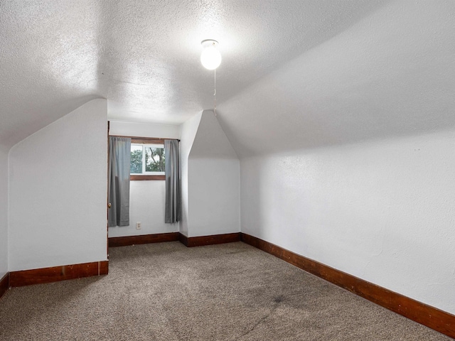 6557 Maple St, Omaha, NE 68104 - additional living space featuring carpet, a textured ceiling, and vaulted ceiling
