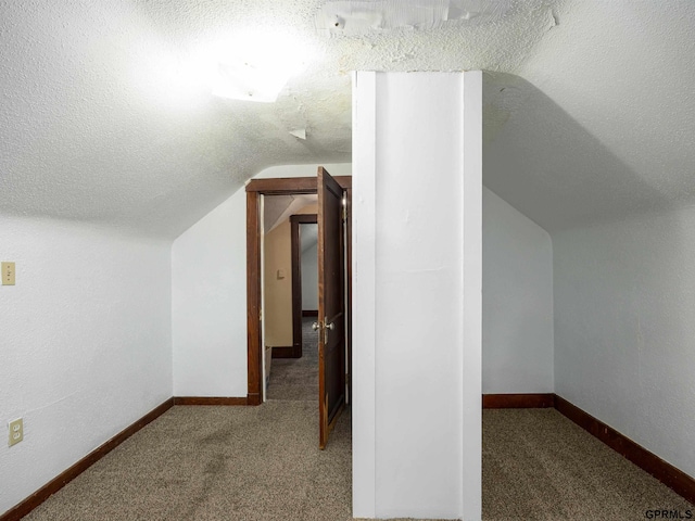 6557 Maple St, Omaha, NE 68104 - additional living space with vaulted ceiling, carpet flooring, and a textured ceiling