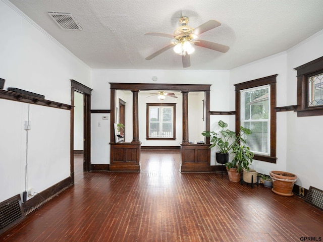 6557 Maple St, Omaha, NE 68104 - living room with dark wood-style floors, ceiling fan, decorative columns, crown molding, and a textured ceiling