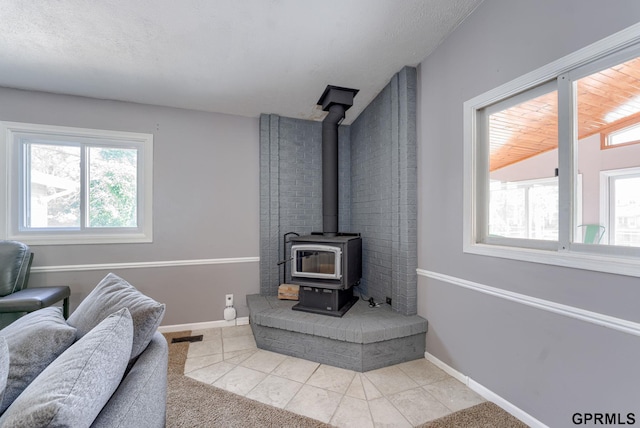 1524 Trumball Ter, Plattsmouth, NE 68048 - tiled living area featuring a wood stove and baseboards