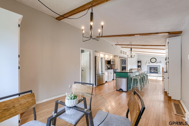 1524 Trumball Ter, Plattsmouth, NE 68048 - dining space featuring a chandelier, light wood-style flooring, and a glass covered fireplace