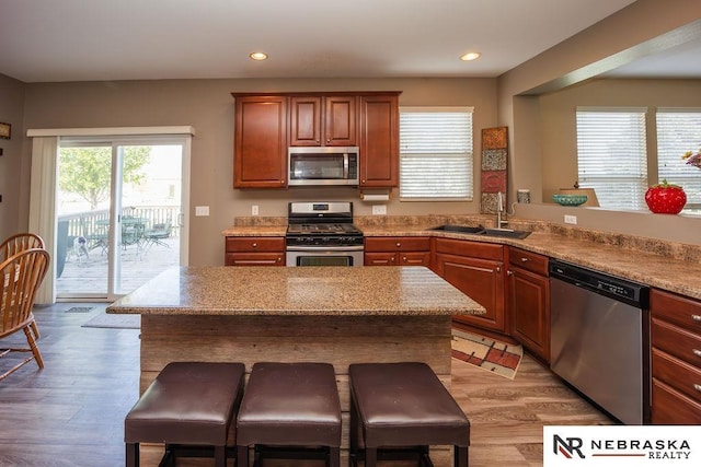 15929 Rosewater Pkwy, Bennington, NE 68007 - kitchen with appliances with stainless steel finishes, a kitchen breakfast bar, light wood-style flooring, recessed lighting, and a center island