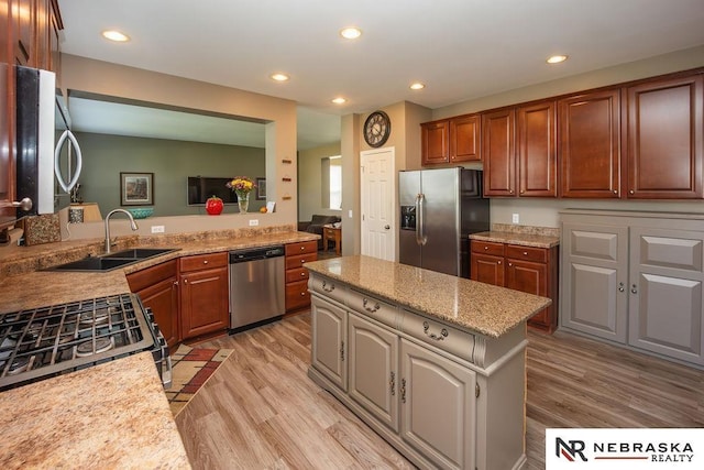 15929 Rosewater Pkwy, Bennington, NE 68007 - kitchen with appliances with stainless steel finishes, a center island, light wood-style flooring, recessed lighting, and light stone counters