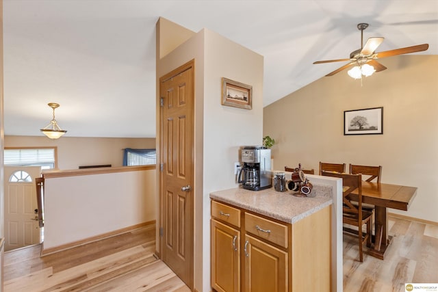 15748 Rosewood St, Omaha, NE 68136 - kitchen featuring a ceiling fan, light wood finished floors, lofted ceiling, light countertops, and pendant lighting