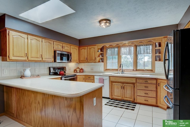 21900 Angus Rd, Gretna, NE 68028 - kitchen featuring stainless steel appliances, a peninsula, a skylight, backsplash, and light countertops