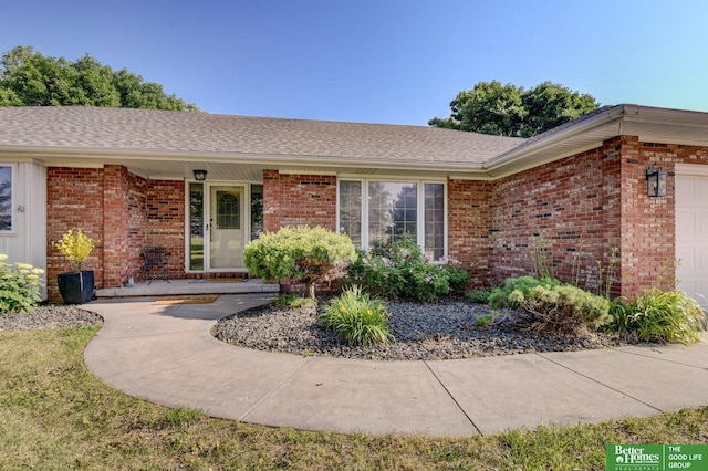 21900 Angus Rd, Gretna, NE 68028 - entrance to property featuring brick siding, a garage, and a shingled roof