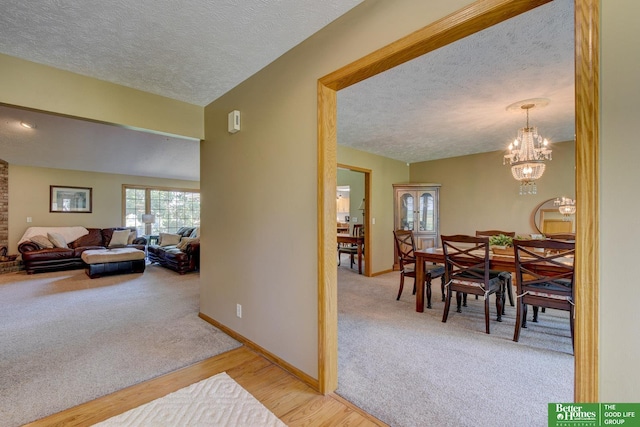 21900 Angus Rd, Gretna, NE 68028 - dining space with a textured ceiling, light carpet, a chandelier, and light wood-type flooring