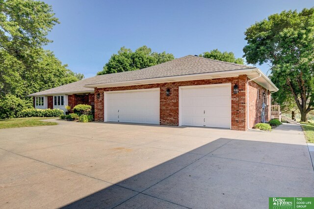 21900 Angus Rd, Gretna, NE 68028 - ranch-style home featuring an attached garage, concrete driveway, brick siding, and a shingled roof