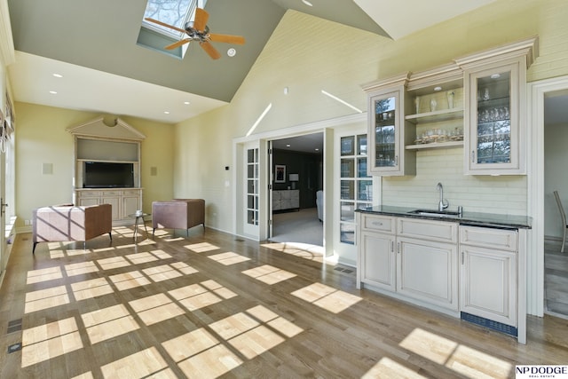 1705 N 102nd St, Omaha, NE 68114 - kitchen featuring dark countertops, ceiling fan, high vaulted ceiling, glass insert cabinets, and open floor plan