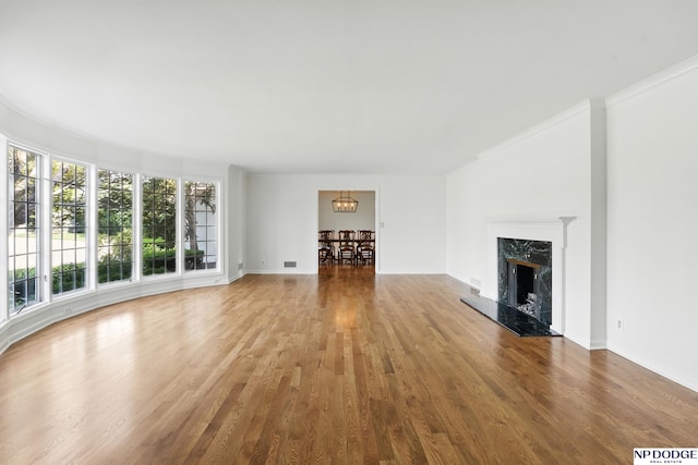 1705 N 102nd St, Omaha, NE 68114 - unfurnished living room featuring a chandelier, wood finished floors, a fireplace, and crown molding