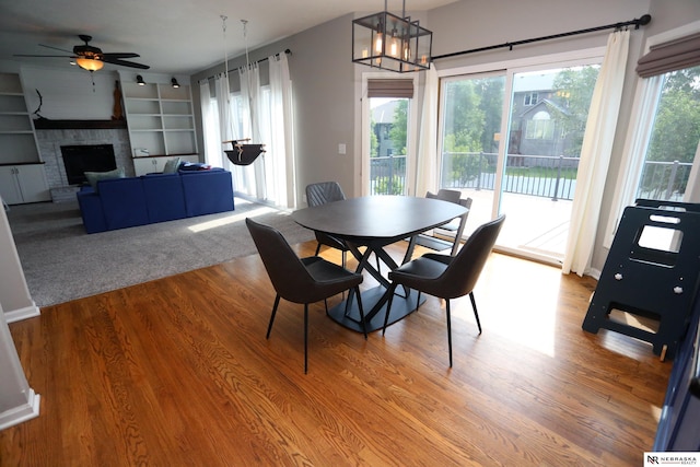 11915 S 53rd St, Papillion, NE 68133 - dining room with ceiling fan, wood finished floors, built in shelves, a chandelier, and a brick fireplace