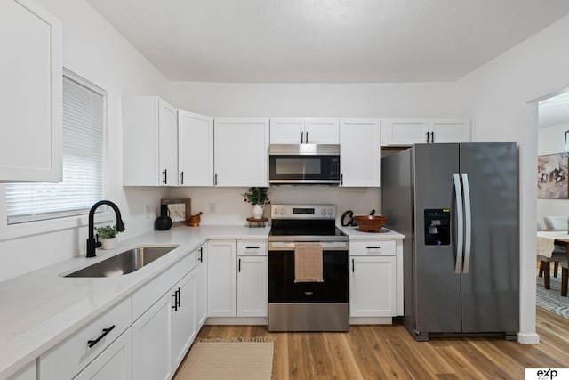 3279 Hascall St, Omaha, NE 68105 - kitchen featuring appliances with stainless steel finishes, white cabinets, and light wood finished floors