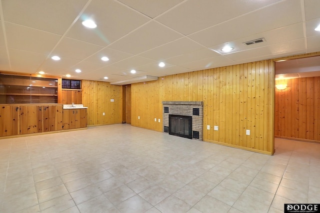 405 W 20th St, Fremont, NE 68025 - unfurnished living room with recessed lighting, a fireplace, wood walls, and a drop ceiling