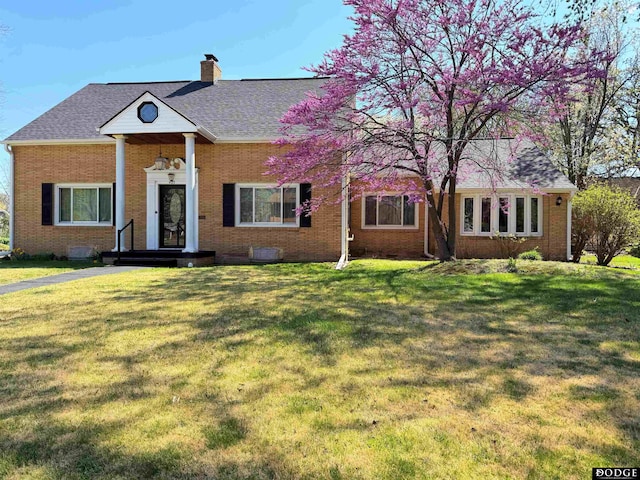 405 W 20th St, Fremont, NE 68025 - neoclassical / greek revival house with brick siding, a chimney, a front yard, and roof with shingles