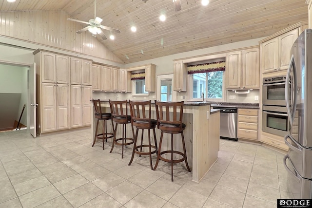 405 W 20th St, Fremont, NE 68025 - kitchen with appliances with stainless steel finishes, high vaulted ceiling, light tile patterned floors, light brown cabinets, and a kitchen bar