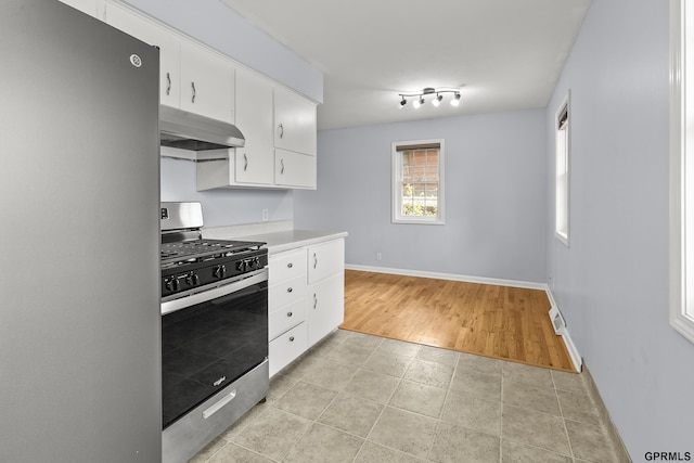 1309 Hansen Ave, Bellevue, NE 68005 - kitchen with stainless steel appliances, ventilation hood, white cabinets, light countertops, and light tile patterned flooring