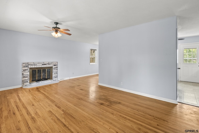 1309 Hansen Ave, Bellevue, NE 68005 - unfurnished living room with ceiling fan, light wood finished floors, and a fireplace
