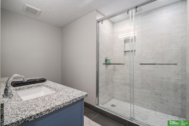 312 S 16th St Unit 904, Omaha, NE 68102 - bathroom featuring a shower stall, vanity, and tile patterned flooring