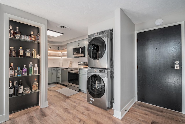 312 S 16th St Unit 904, Omaha, NE 68102 - laundry area featuring stacked washing machine and dryer and light wood finished floors