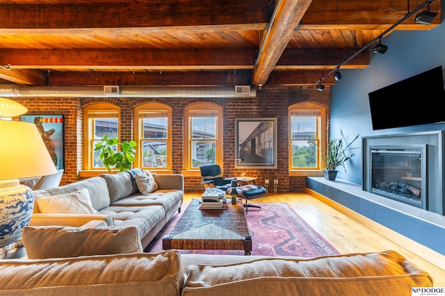 105 S 9th St Unit 308, Omaha, NE 68102 - living area featuring brick wall, a wood ceiling with exposed beams, plenty of natural light, track lighting, and wood finished floors