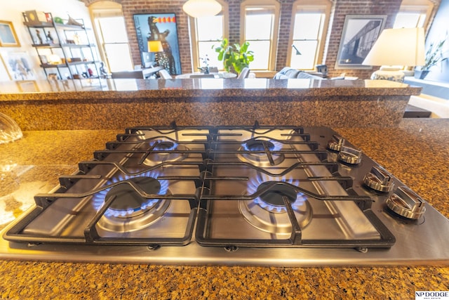 105 S 9th St Unit 308, Omaha, NE 68102 - detailed view of stainless steel gas cooktop, brick wall, and dark countertops
