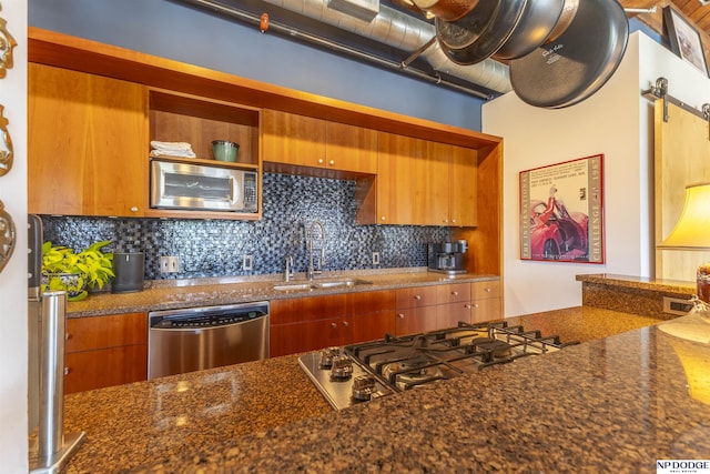 105 S 9th St Unit 308, Omaha, NE 68102 - kitchen featuring appliances with stainless steel finishes, tasteful backsplash, brown cabinets, dark stone countertops, and open shelves