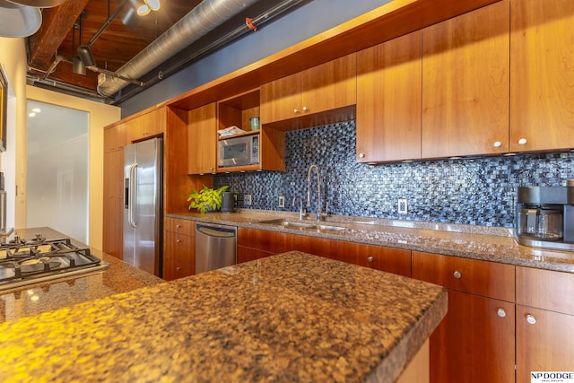 105 S 9th St Unit 308, Omaha, NE 68102 - kitchen featuring stainless steel appliances, decorative backsplash, dark stone counters, and brown cabinets
