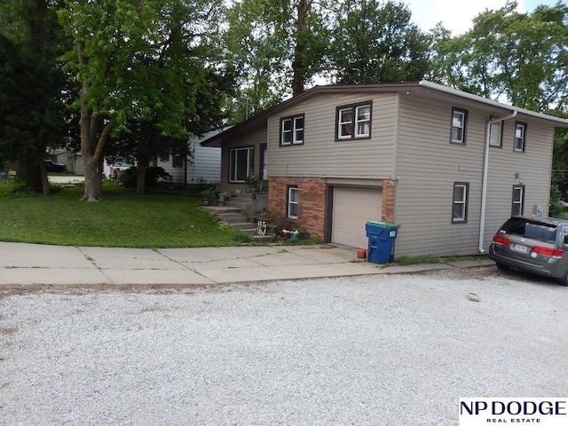 4501 S 48th St, Lincoln, NE 68516 - split level home featuring driveway, a garage, a front yard, and brick siding
