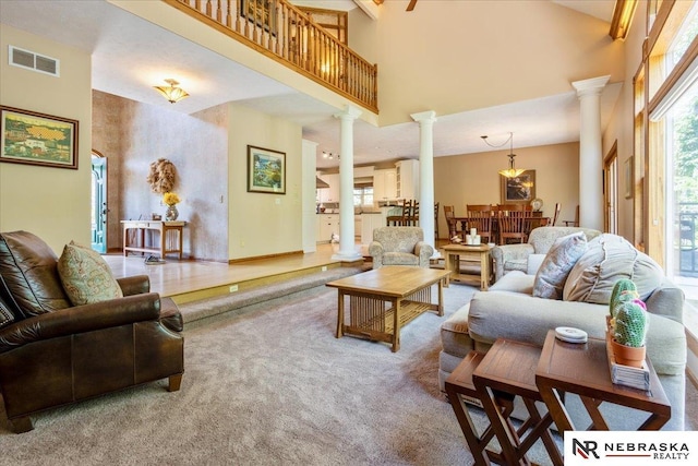 19807 Sterling Ct, Plattsmouth, NE 68048 - carpeted living area featuring ornate columns, a towering ceiling, and a chandelier