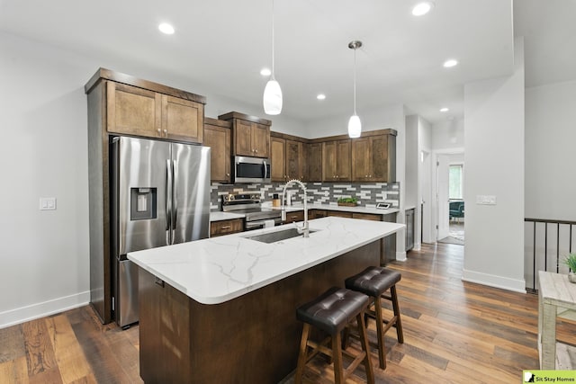 15436 Fowler Ave, Omaha, NE 68116 - kitchen featuring appliances with stainless steel finishes, decorative backsplash, dark wood finished floors, recessed lighting, and light stone counters