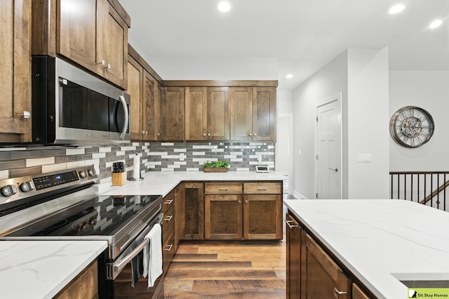 15436 Fowler Ave, Omaha, NE 68116 - kitchen with appliances with stainless steel finishes, light wood-style floors, backsplash, recessed lighting, and light stone countertops