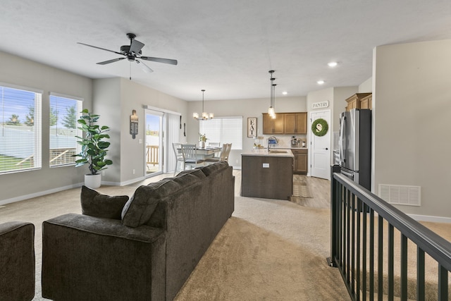 5003 N 180th Ave, Elkhorn, NE 68022 - living area with light carpet, a ceiling fan, a chandelier, and recessed lighting