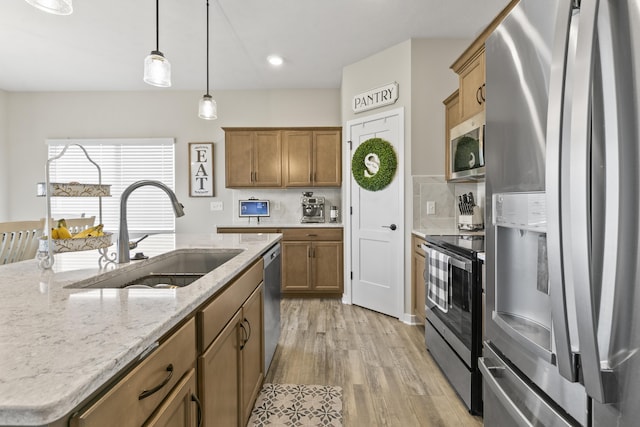 5003 N 180th Ave, Elkhorn, NE 68022 - kitchen with appliances with stainless steel finishes, light wood finished floors, brown cabinets, pendant lighting, and recessed lighting