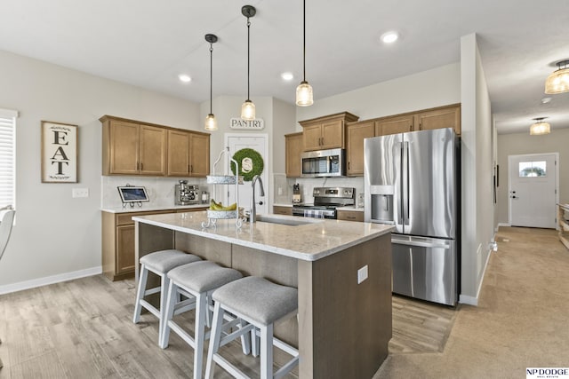 5003 N 180th Ave, Elkhorn, NE 68022 - kitchen featuring stainless steel appliances, brown cabinets, a breakfast bar area, a kitchen island with sink, and recessed lighting