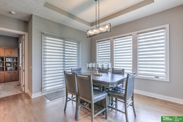20761 Shirley St, Omaha, NE 68022 - dining area featuring wood finished floors, a chandelier, and a raised ceiling