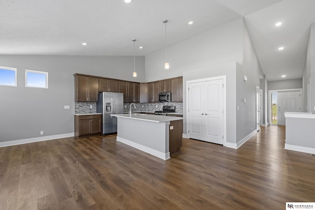 7530 Augustine Ave, Lincoln, NE 68516 - kitchen with appliances with stainless steel finishes, backsplash, light countertops, high vaulted ceiling, and a kitchen island with sink