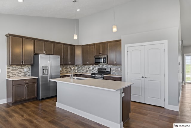 7530 Augustine Ave, Lincoln, NE 68516 - kitchen featuring stainless steel appliances, high vaulted ceiling, dark brown cabinets, backsplash, and light countertops