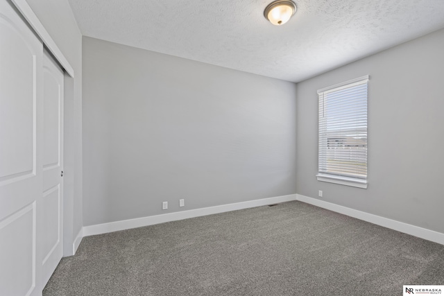 7530 Augustine Ave, Lincoln, NE 68516 - unfurnished bedroom with carpet floors, a textured ceiling, and a closet
