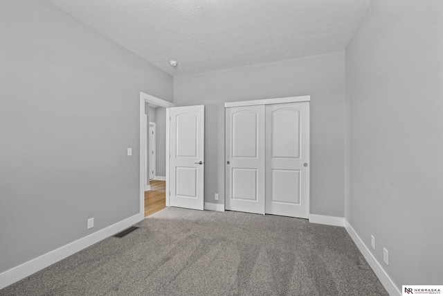 7530 Augustine Ave, Lincoln, NE 68516 - unfurnished bedroom with carpet, a closet, and a textured ceiling