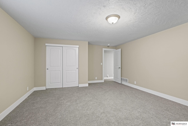 7530 Augustine Ave, Lincoln, NE 68516 - unfurnished bedroom featuring carpet floors, a closet, and a textured ceiling