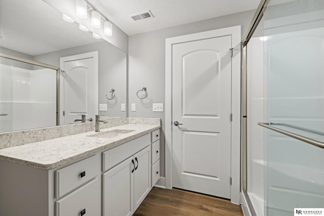 7530 Augustine Ave, Lincoln, NE 68516 - bathroom with vanity, wood finished floors, and a stall shower