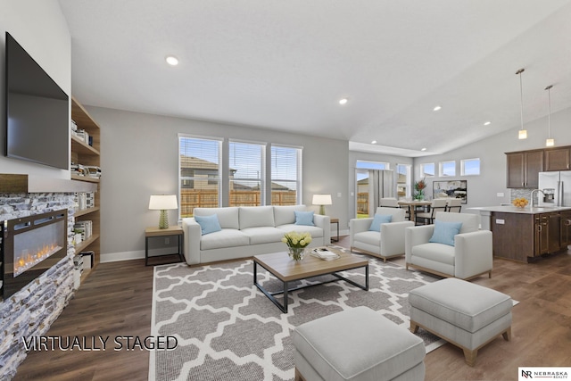 7530 Augustine Ave, Lincoln, NE 68516 - living room with recessed lighting, a stone fireplace, wood finished floors, and lofted ceiling
